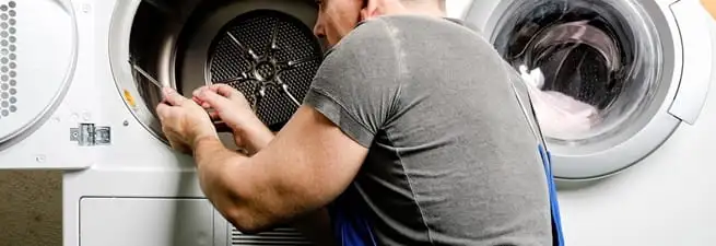 Dryer repair technician fixing a clothes dryer drum in Fresno, CA