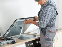 Appliance repair technician installing a built-in cooktop in Fresno, CA