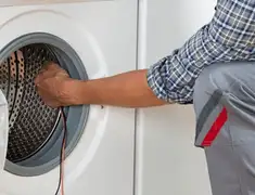 Dryer repair technician diagnosing and servicing a clothes dryer in Fresno, CA