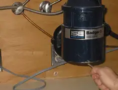 Garbage disposal repair technician tightening the mounting ring under a sink in Fresno, CA