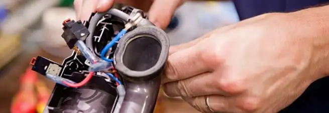 Vacuum repair technician reconnecting wiring and components in Fresno, CA