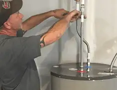 Water heater repair technician tightening supply line connections in Fresno, CA